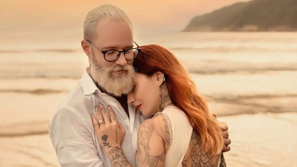 A couple hugging each other at a beach.