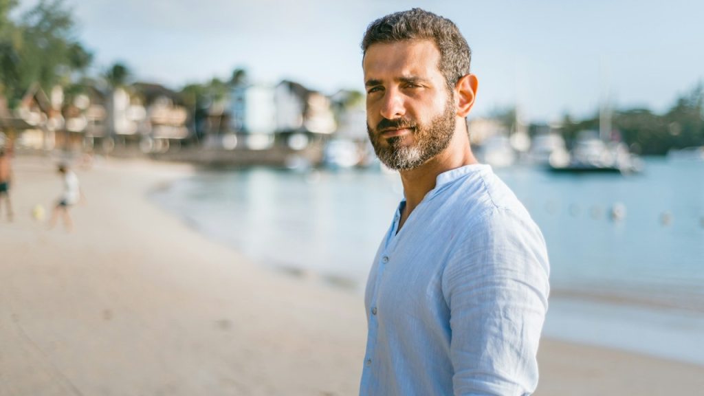A man standing on the beach during the daytime.