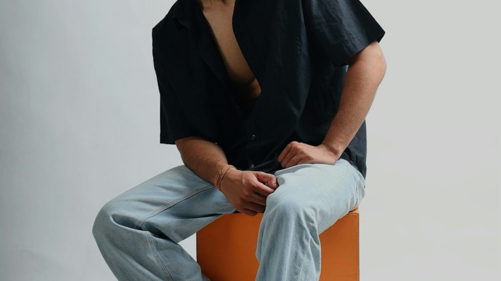 A man sitting on top of an orange block.