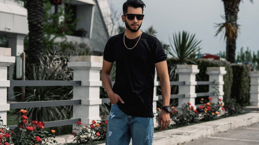 A man in a black shirt and denim pants.