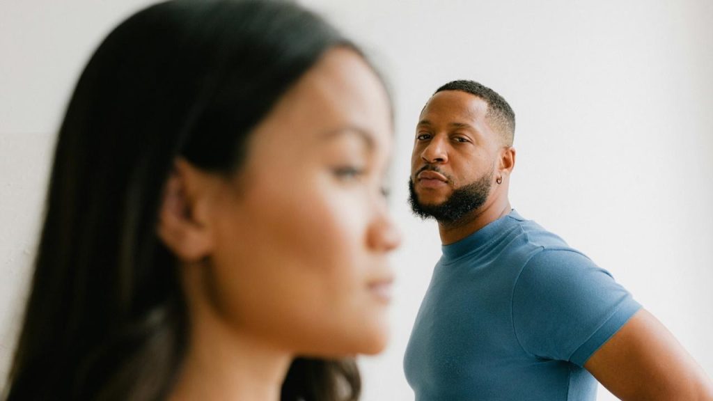 A bearded man looking at a woman.