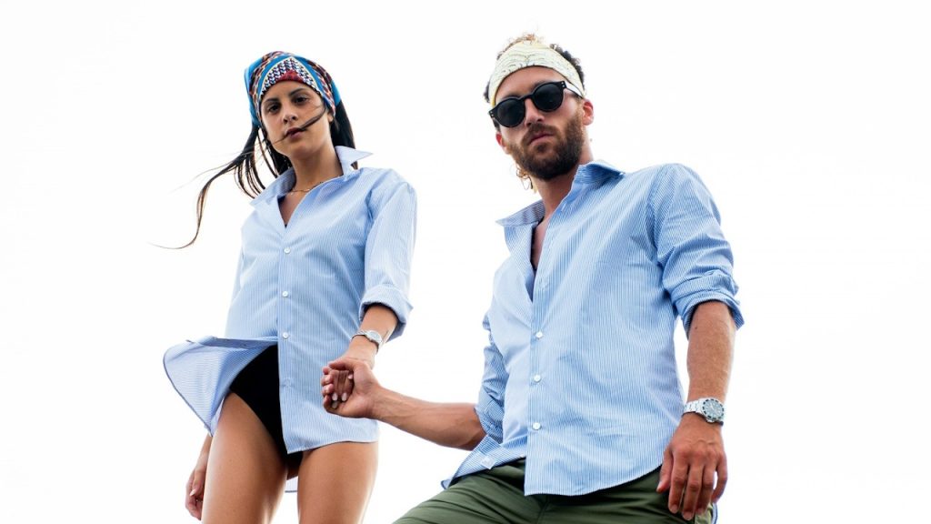 A man and a woman in light blue dress shirts with their sleeves rolled.