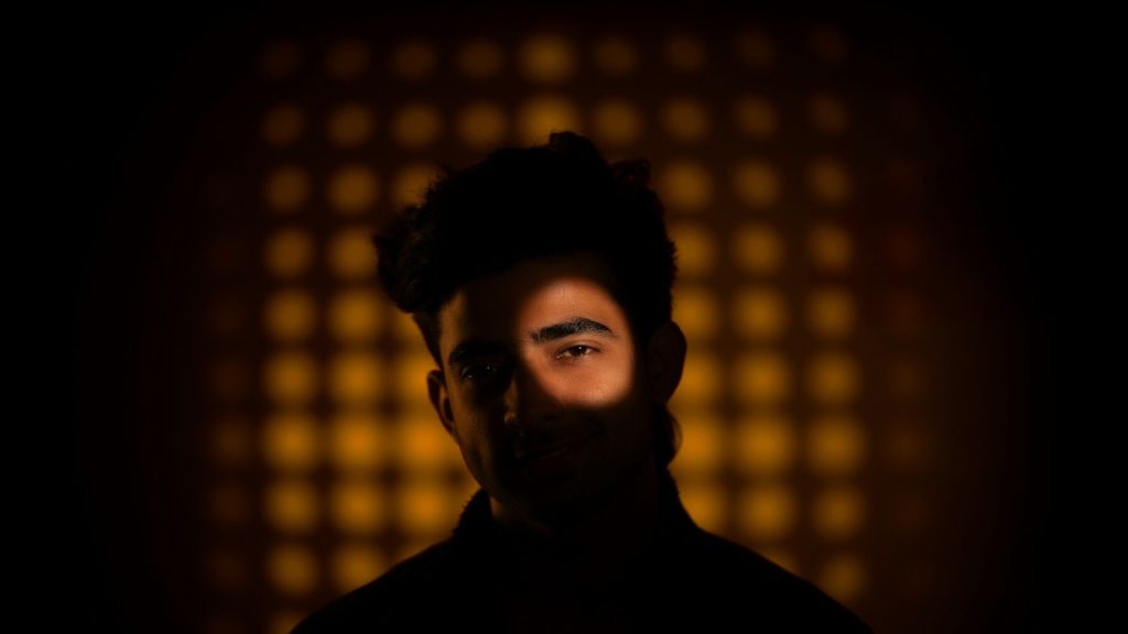 A man has one eye lit.