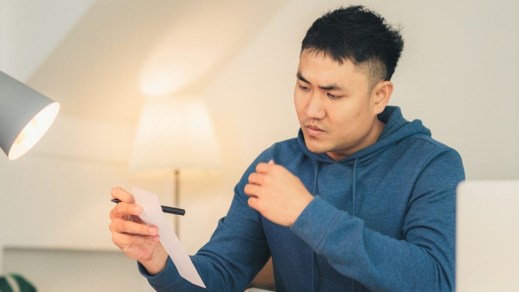 A frustrated man reading a document.