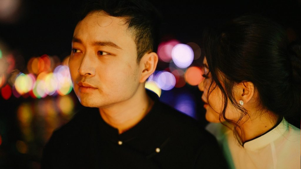 A man and woman in bokeh lights at night.