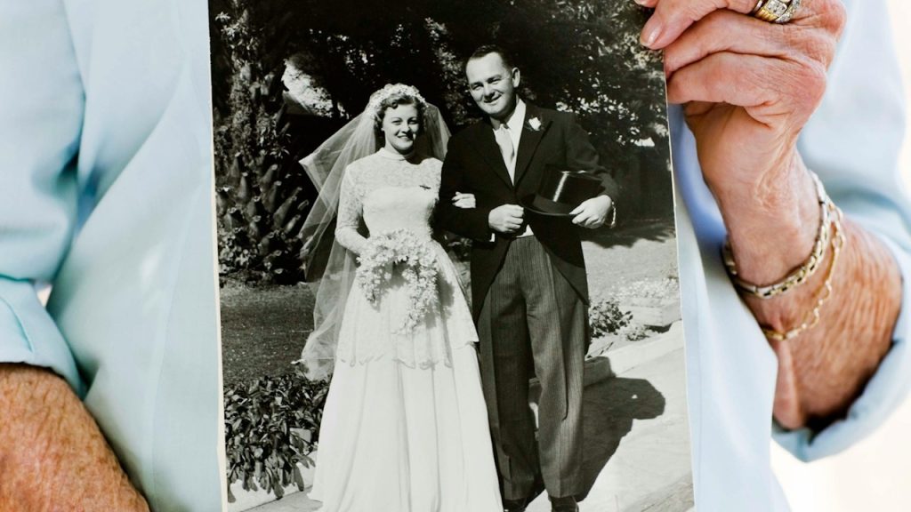 A person holding an old wedding picture.