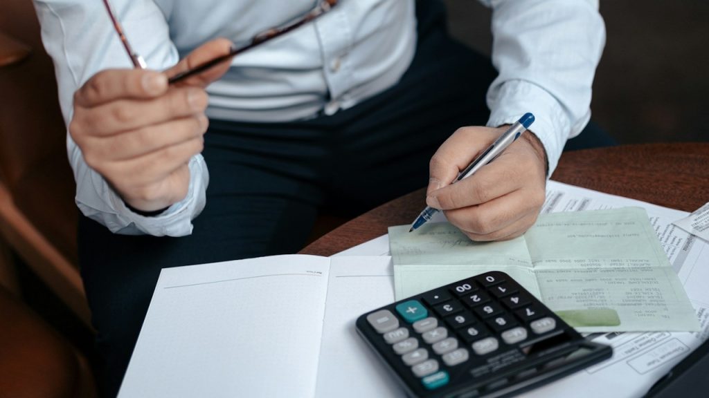 A man performing calculations on a calculator.