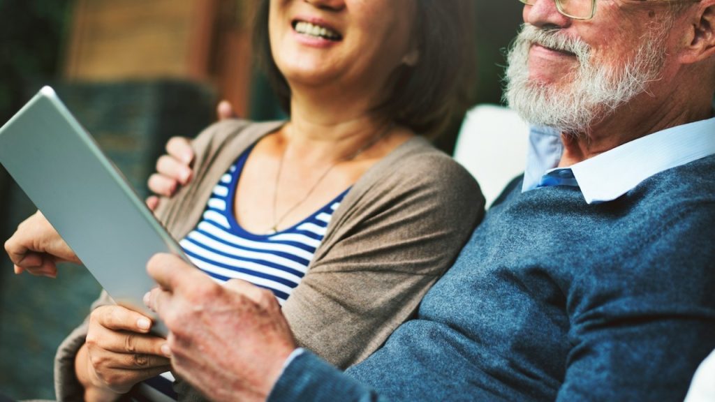 A couple with different age groups laughing and sitting.