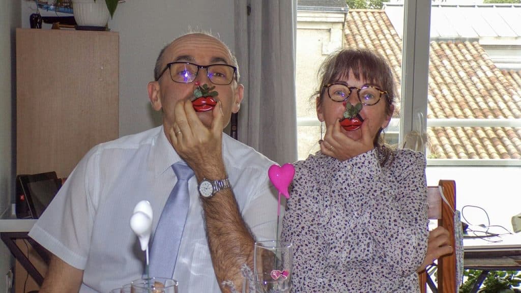 An old man and a woman sitting at a table posing for a picture.