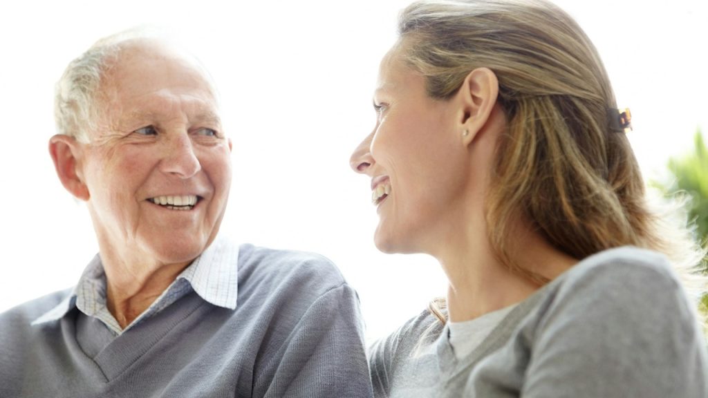 An older man smiling at a younger woman.