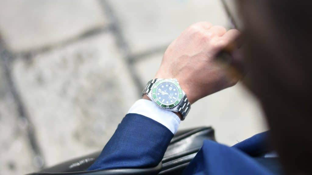 Person looking at silver-colored analog watch.