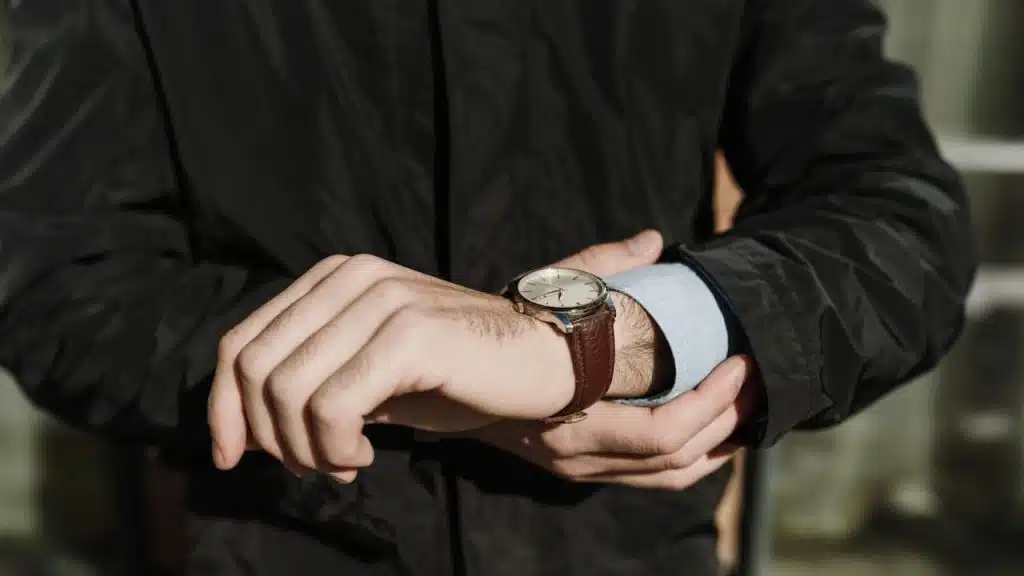 A man wearing a watch with a leather strap.