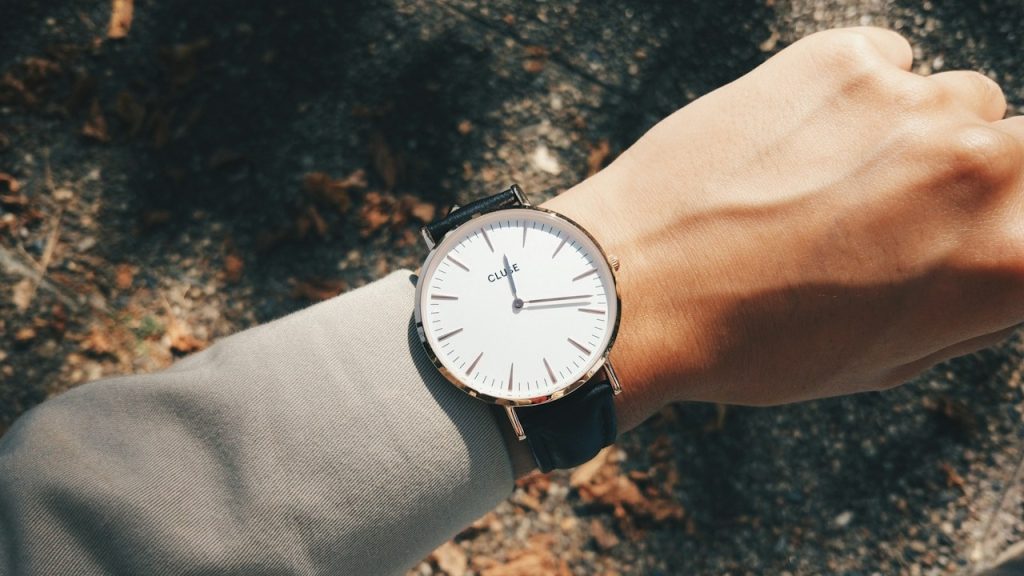 Person wearing a round, silver-colored analog watch.
