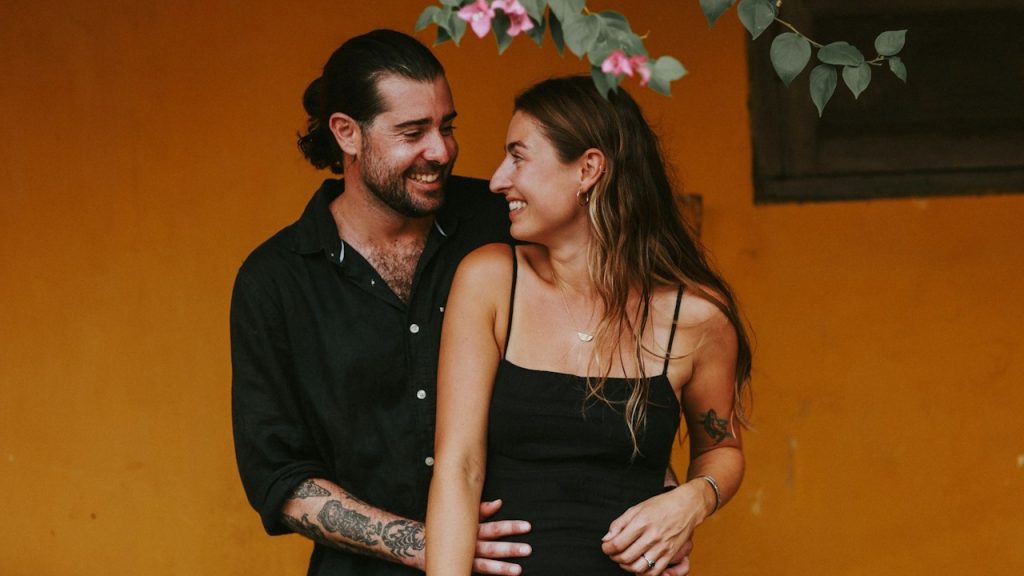 A happy man holding a woman on his back.