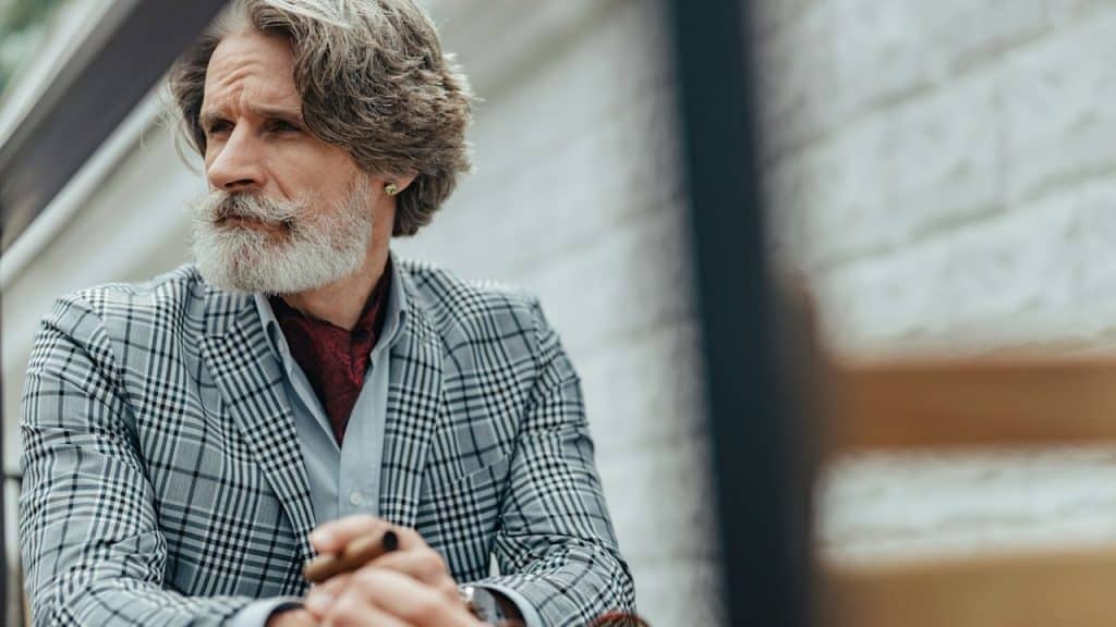 Handsome bearded gentleman looking away with a serious expression.