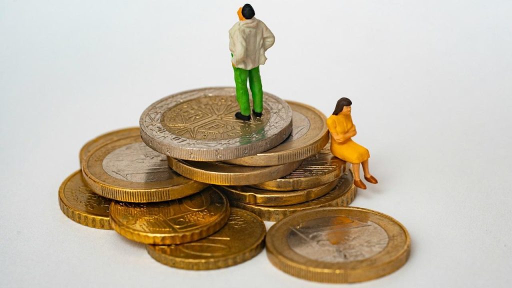 Two ceramic figurines on a stack of coins.
