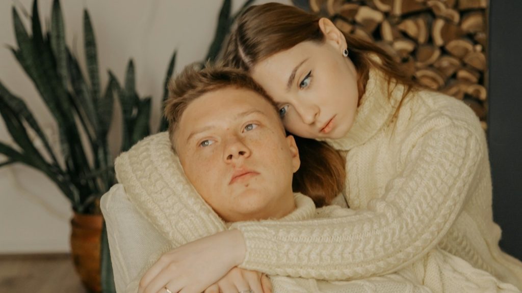 A man and a woman lying on a couch.