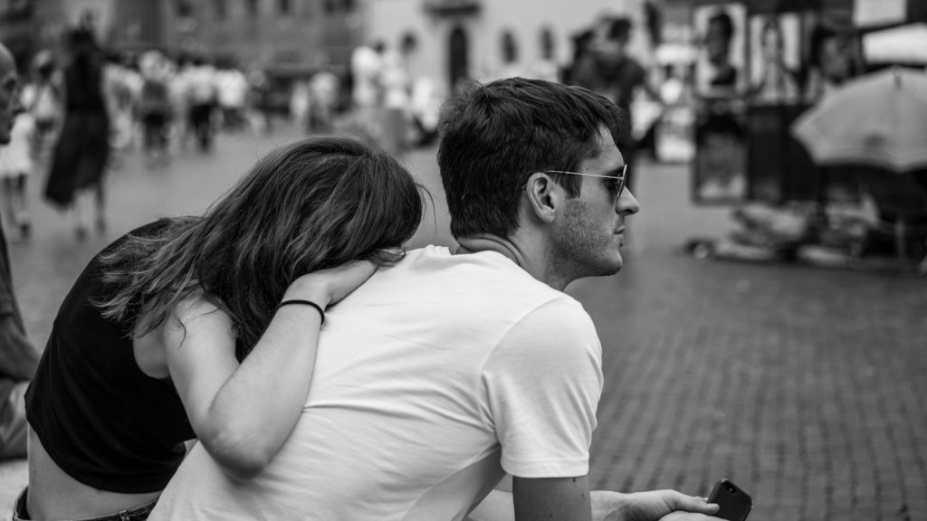 A man and a woman sitting on a bench.