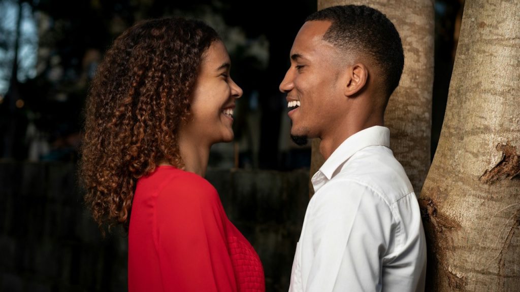 A couple laughing while looking in the eyes of each other.