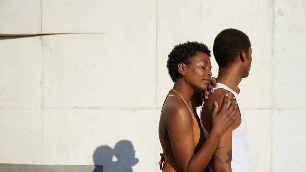 A woman holding a man from the backside.