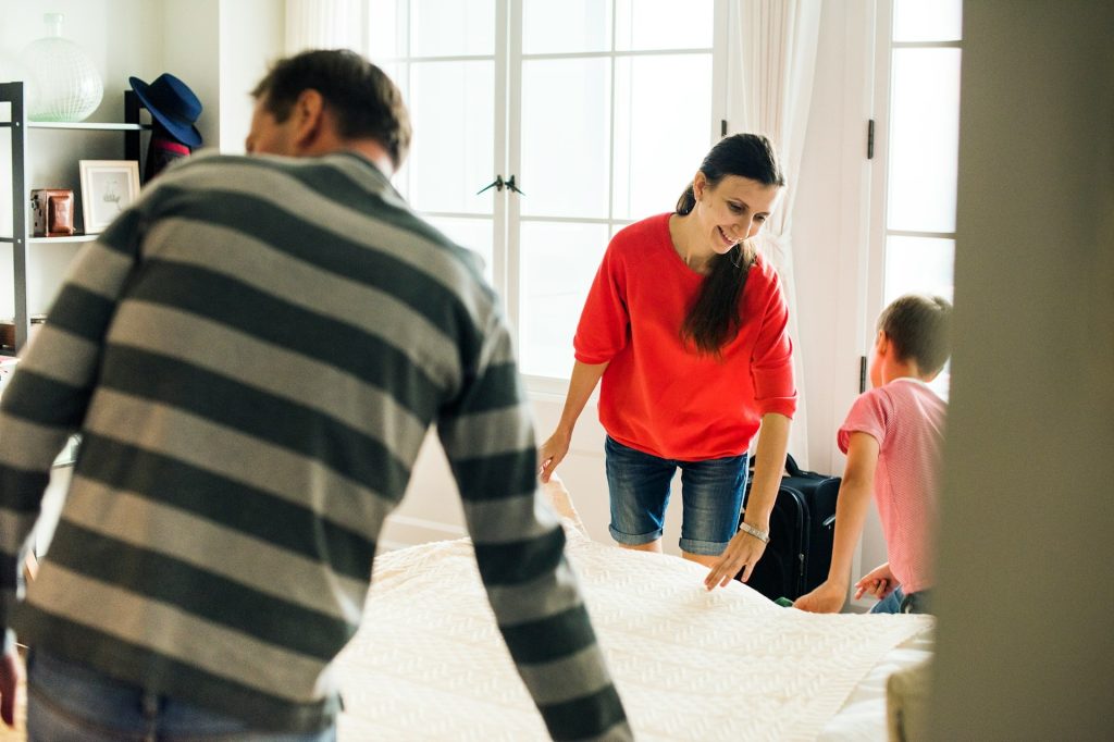 A family making a bed together.