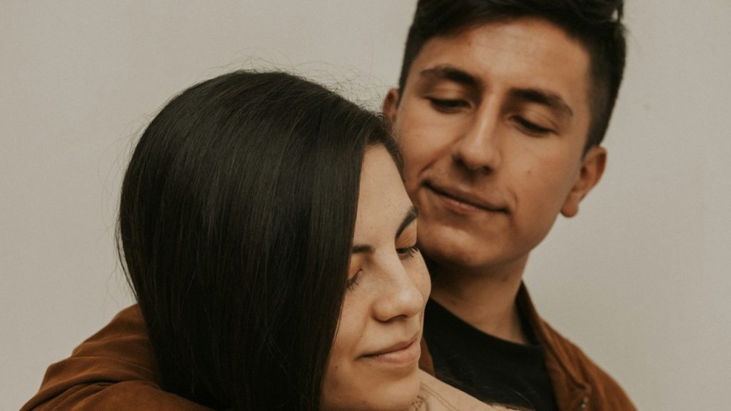 A man hugging a woman from behind.