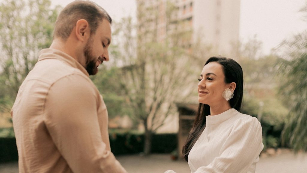 A man and a woman holding hands on a bridge.