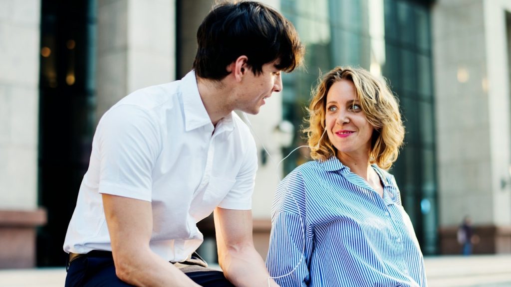 A smiling woman looking at a man who looks at her.