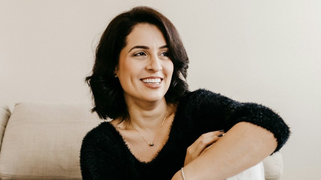 A woman smiling and looking to the side.