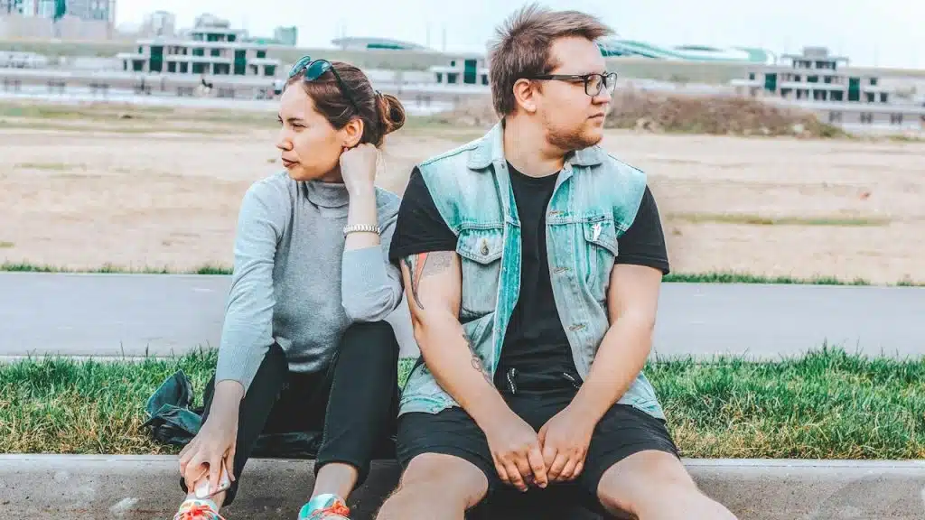 A couple sitting on the footpath while running.