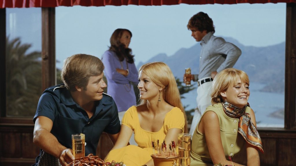 A group of people sitting around a wooden table.