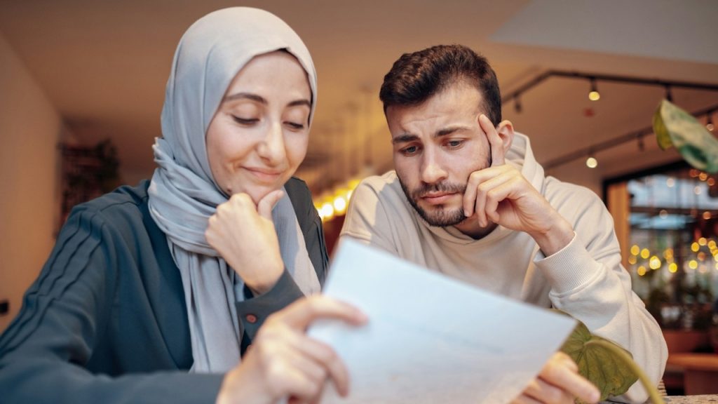 A man and a woman looking at a piece of paper.