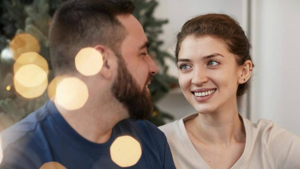 A couple looking at each other while sitting close to each other.