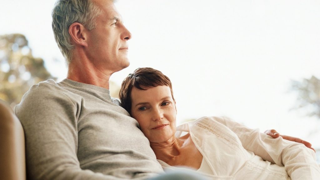 A man and a woman sitting together on a couch.