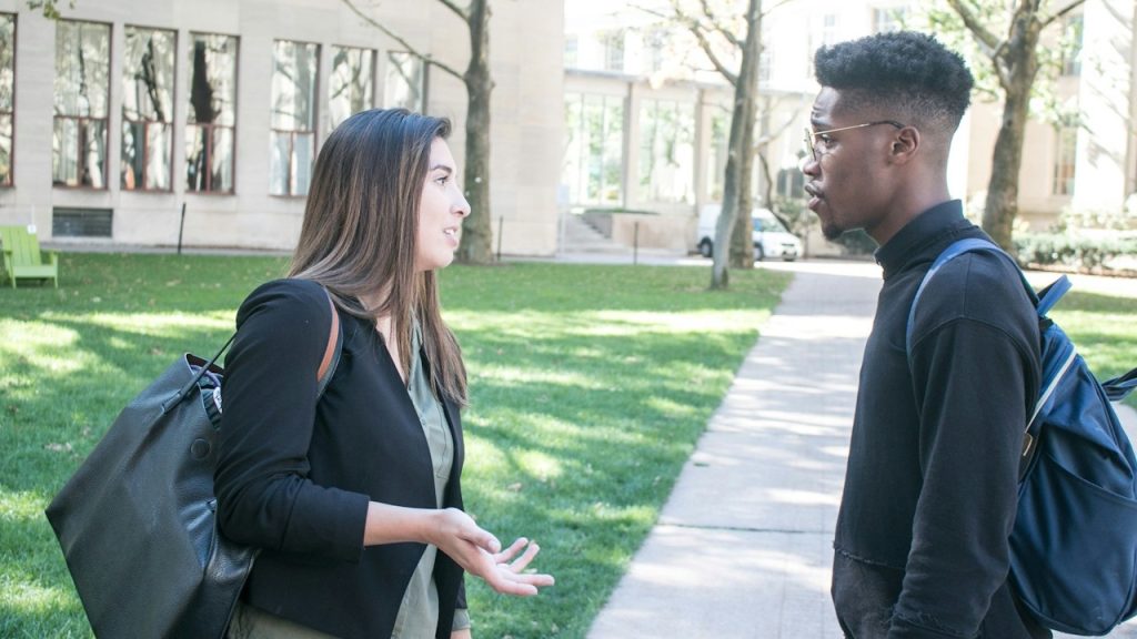 A man standing next to a woman on a sidewalk.