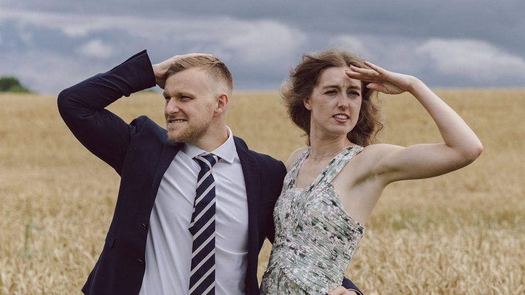 A man and a woman standing in a field.