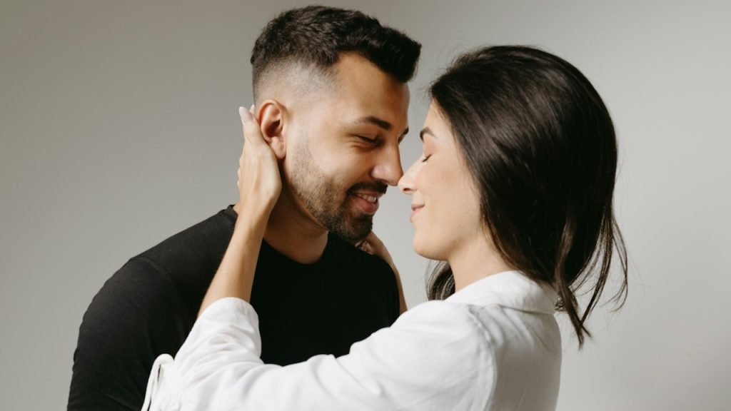 A man and a woman touching noses with each other.