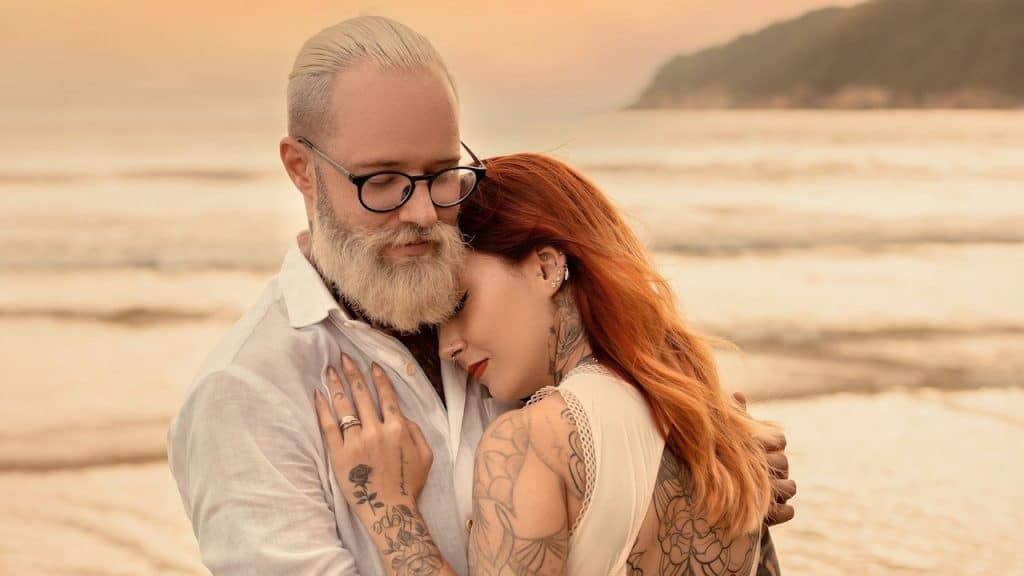 A couple hugging each other on a beach.