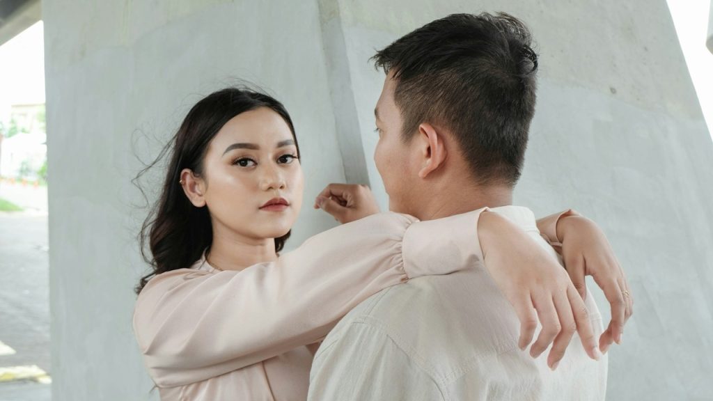 A woman in a pink top with her arm around a man in a white shirt