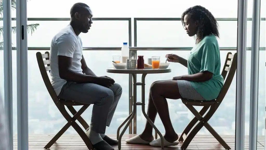 A couple having breakfast while sitting quietly at a table.