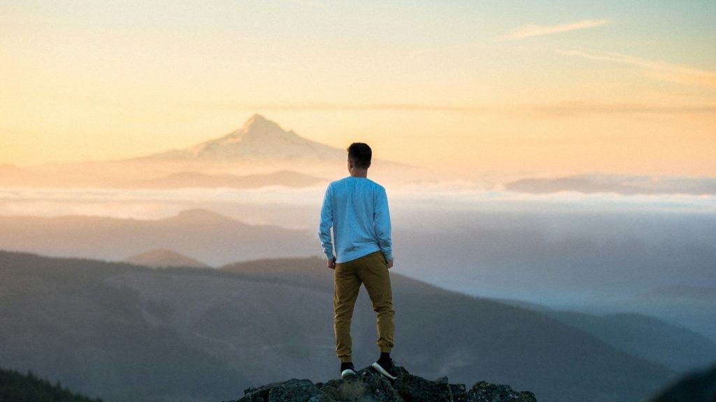 A man standing on the top of a hill.