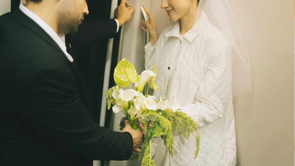 A man in a suit gives a woman a bouquet.