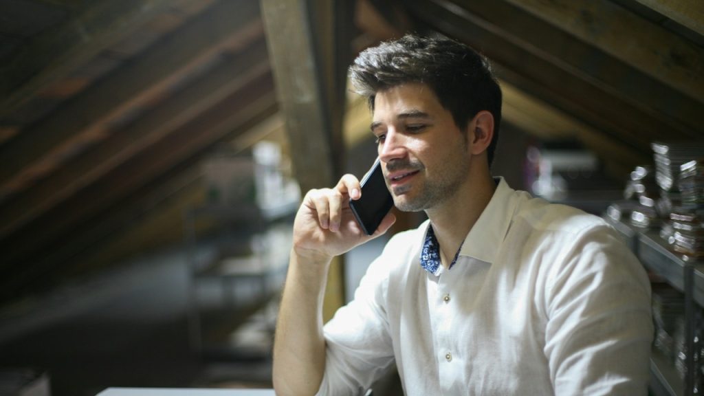 A man sitting alone is calling on phone.
