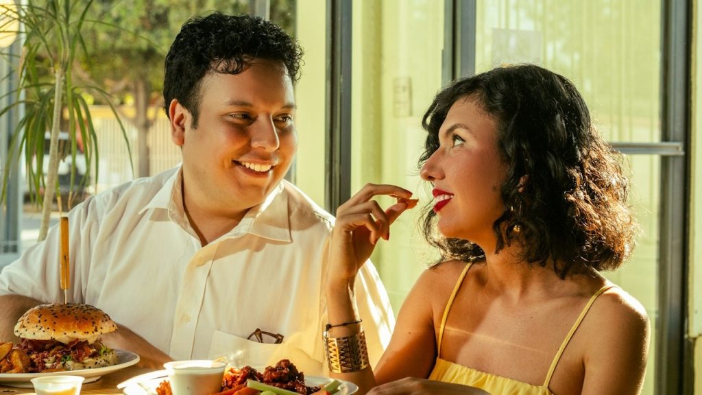 A couple shares food and laughs together.