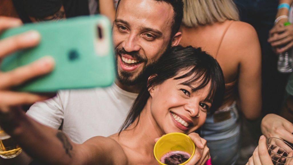 A man and woman holding yellow ceramic mugs.