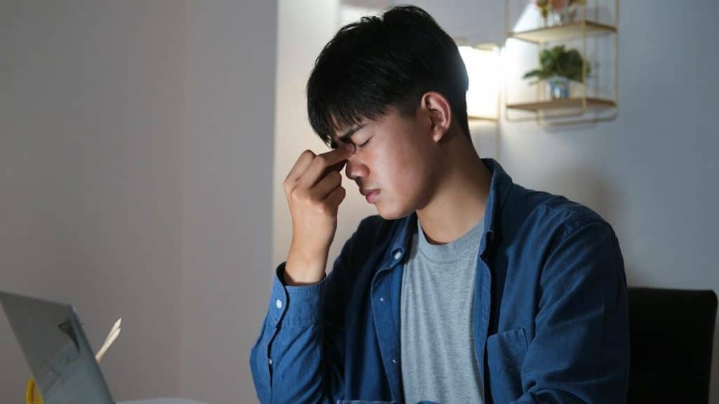 Young man working overtime and feeling tired.