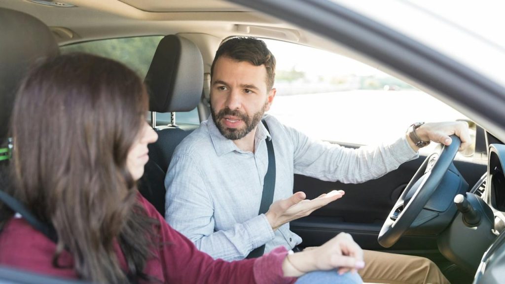 A man driving while quarreling with a woman in the car.