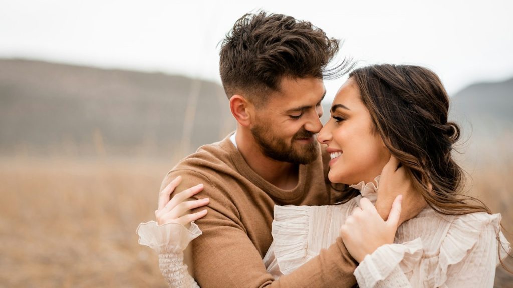 A loving couple embraces and smiles at each other.