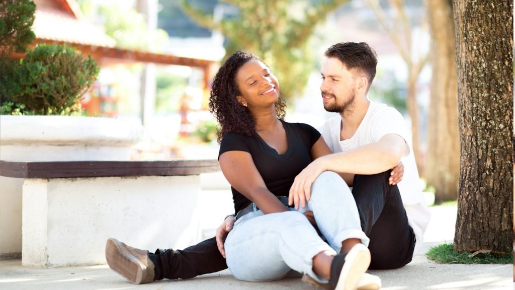 A happy couple sitting in the square, talking and exchanging affection.