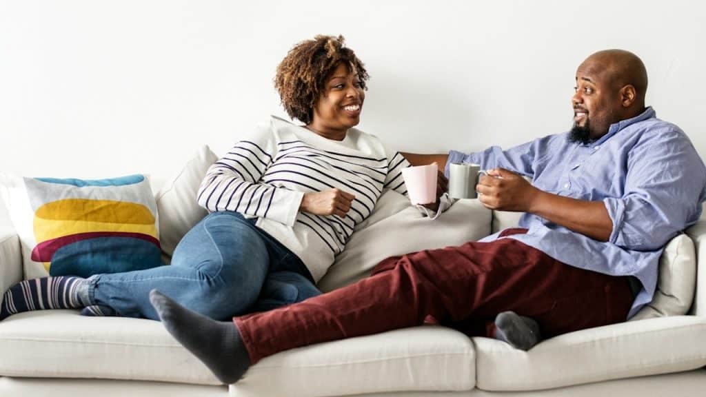 A couple having tea while relaxing on the sofa.
